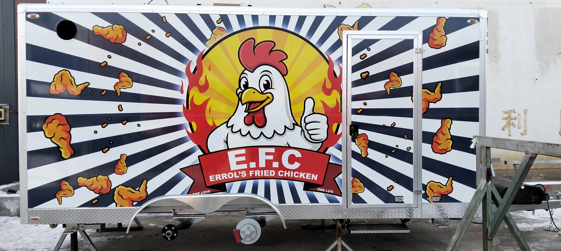 Custom chicken-themed wrap on a food trailer