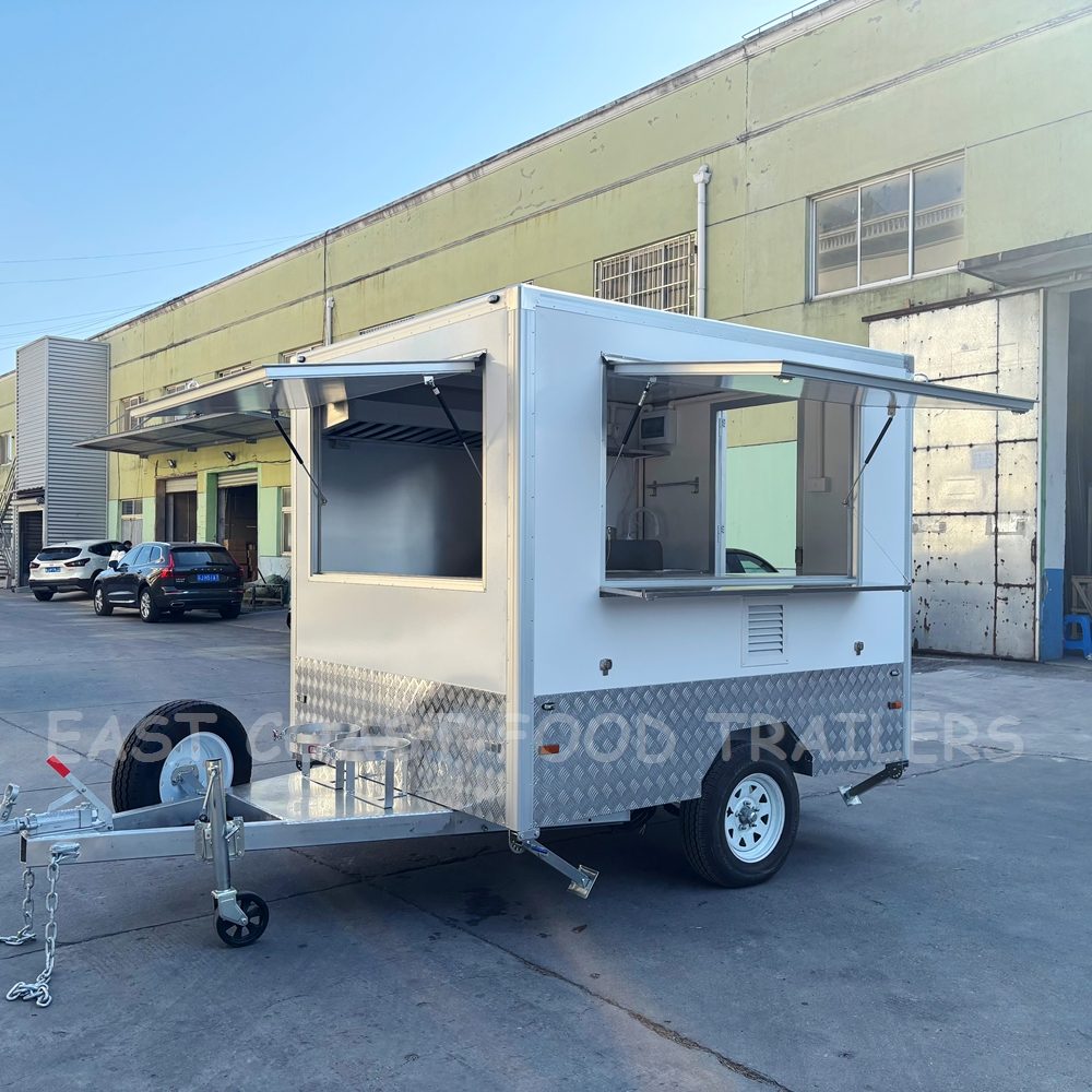 Compact white food trailer with serving hatch